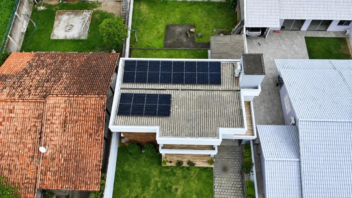 Residência com sistema fotovoltaico em telhado de fibrocimento, vista de drone