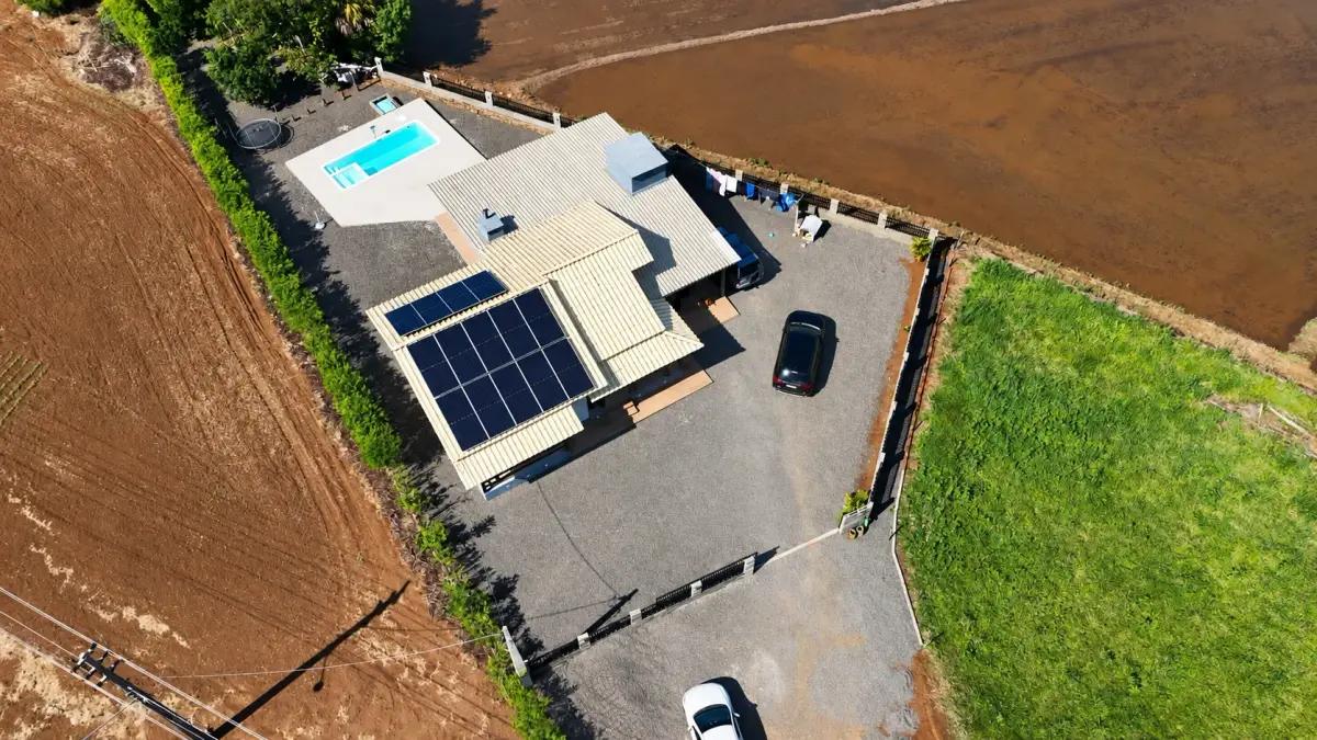 Sistema de 14 módulos solares numa propriedade rural, vista de drone